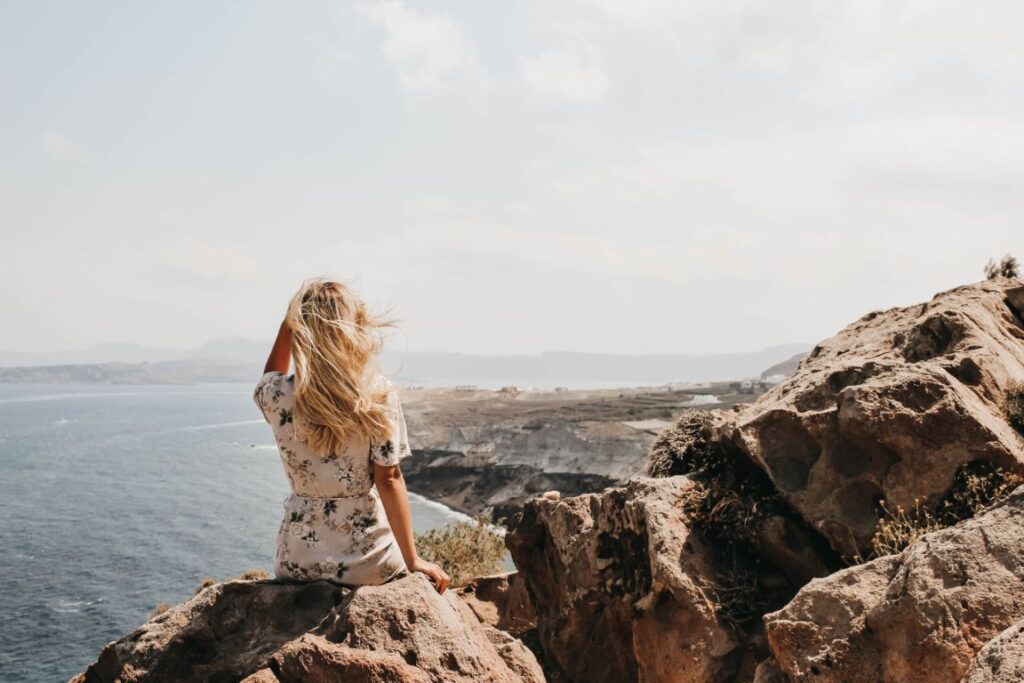 Adventurous solo female traveler cliff edge-view