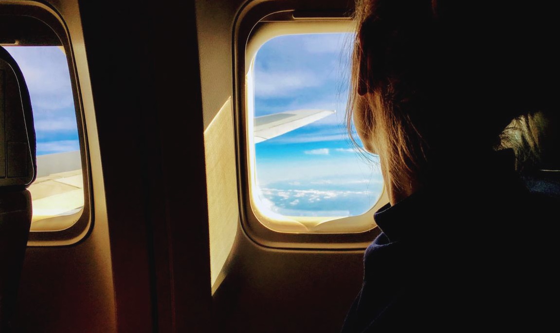 Solo female traveler on airplane window view