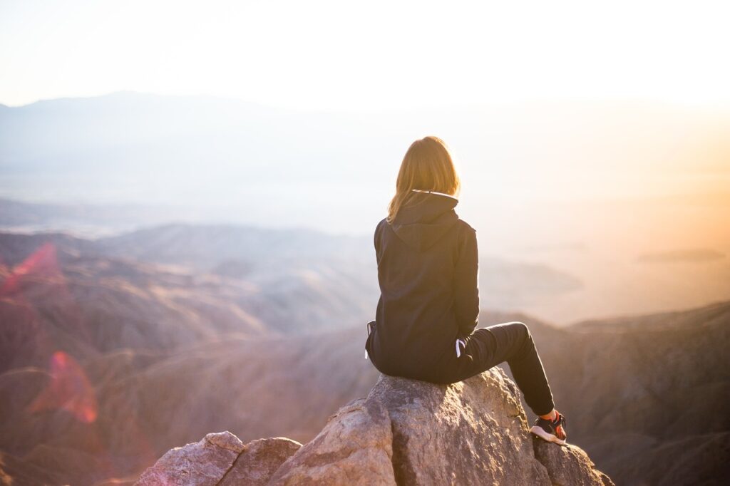 Solo woman hiker on mountain peak